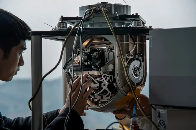 Engineer assembling the internal components of a HITS stabilised gimbal camera payload