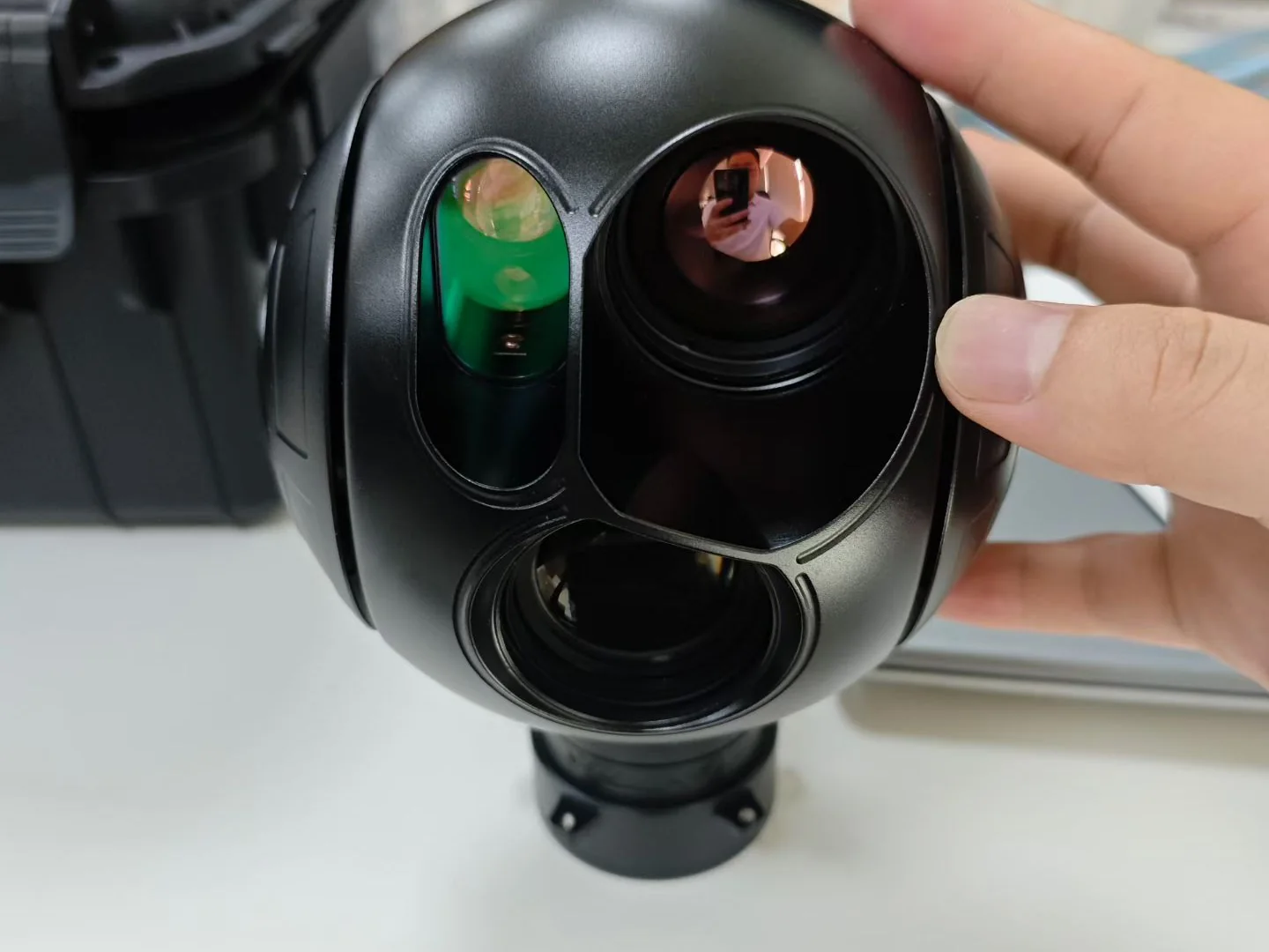 Black dual-sensor gimbal camera payload held for inspection