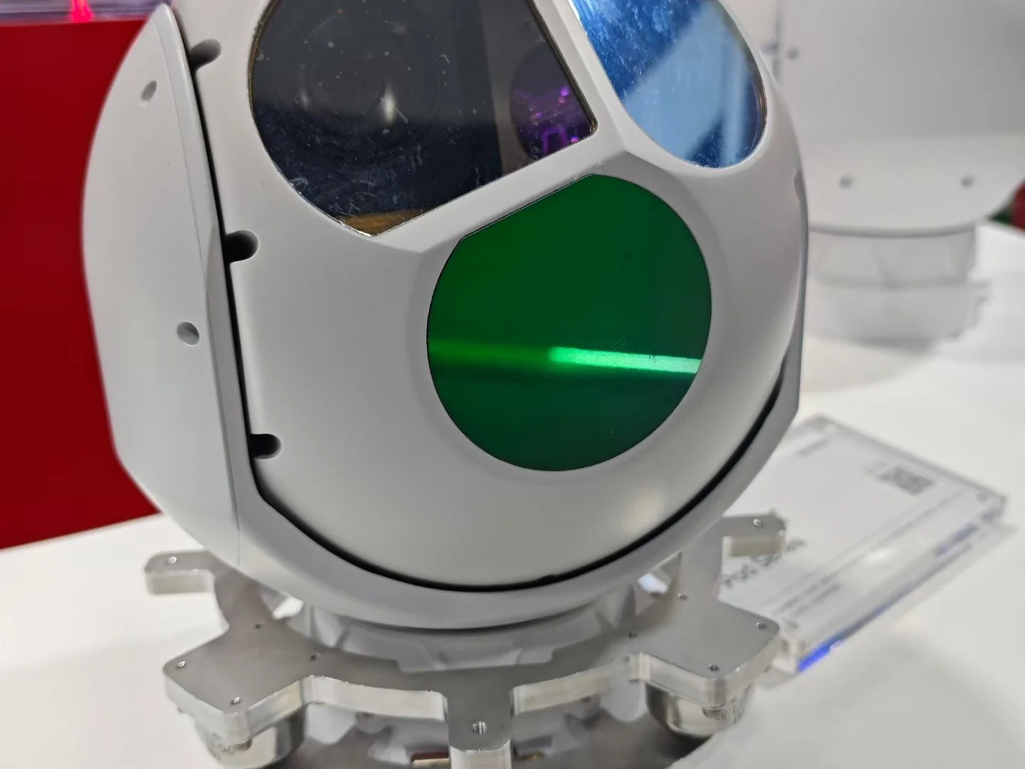 White stabilised gimbal camera payload with a coated daylight lens window