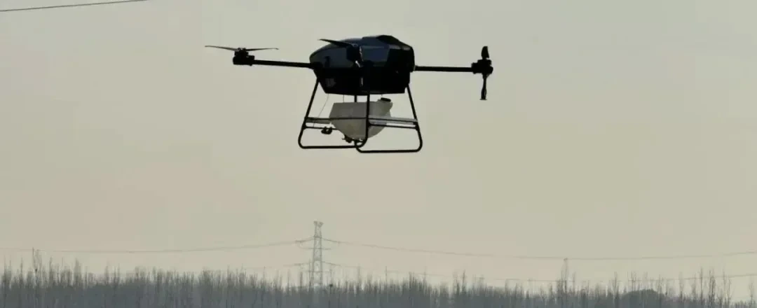 Multirotor UAV carrying a payload in flight over open farmland