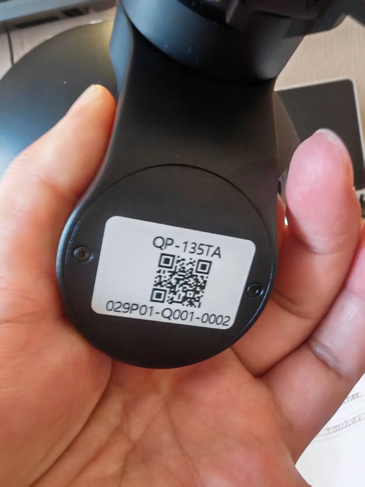Serial number and QR label on the housing of a HITS gimbal camera payload, held for inspection