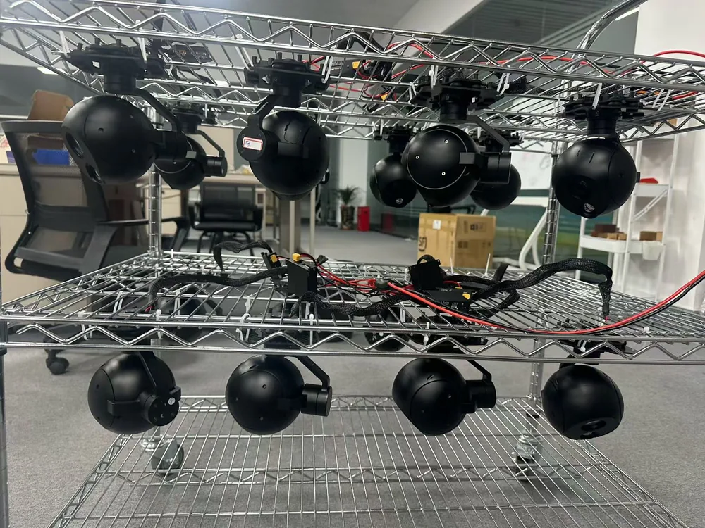 A batch of HITS gimbal camera payloads hanging on a production test rack before packing